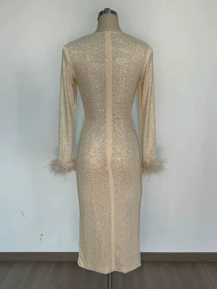 Robe chic à paillettes dorées avec détails de plumes