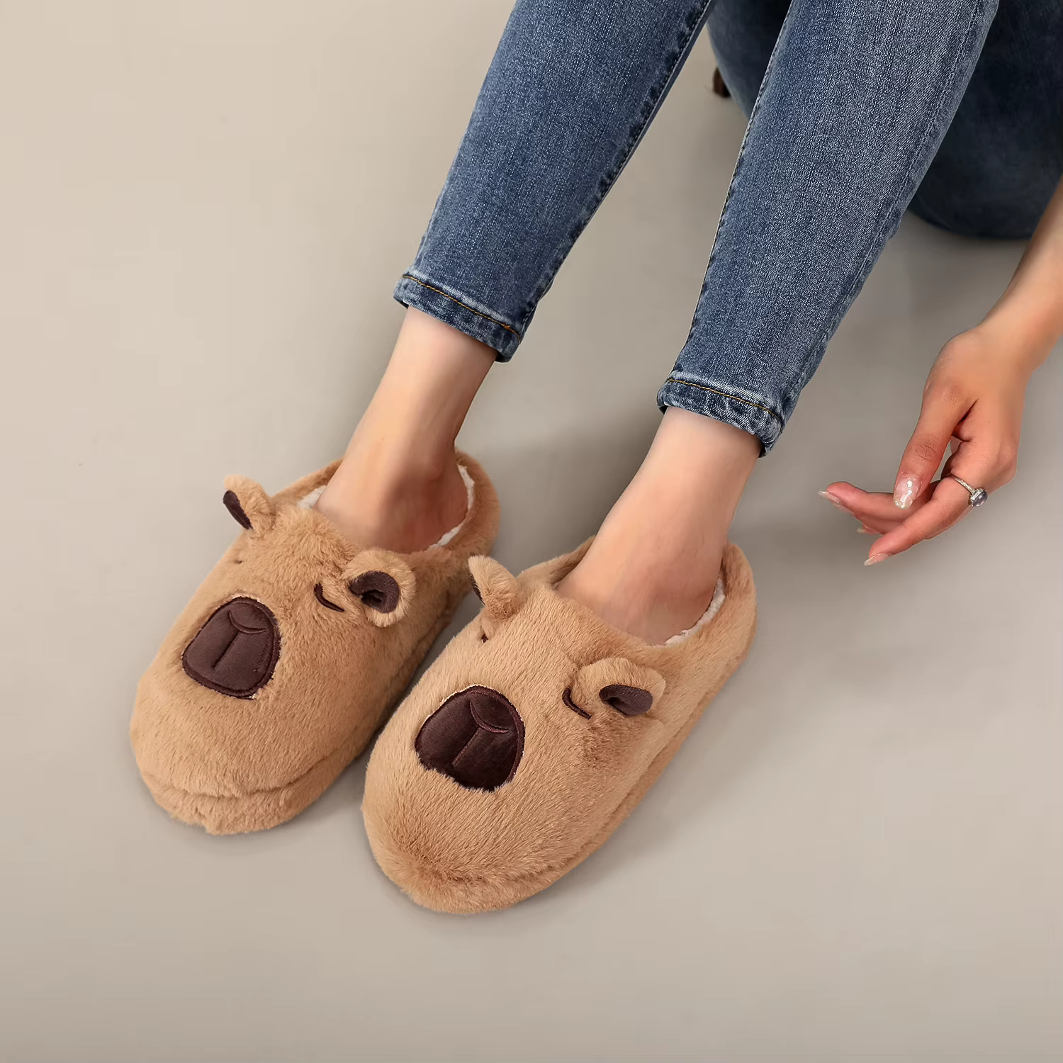 Une paire de pantoufles d'intérieur en fourrure à motif animal capybara marron